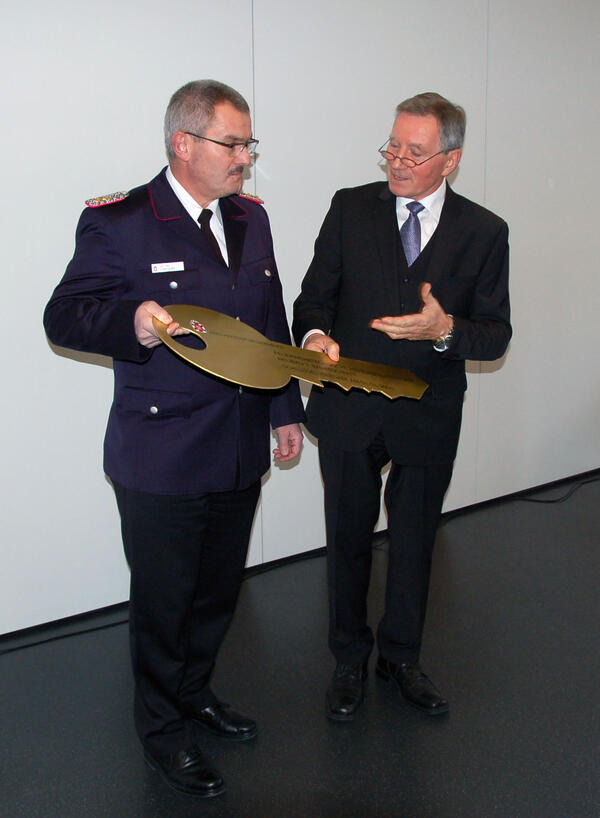 Kreisbrandmeister Michael Raddatz (links) erhält von Kreispräsidenten Meinhard Füllner den symbolischen Schlüssel für den fertiggestellten Erweiterungsbau
